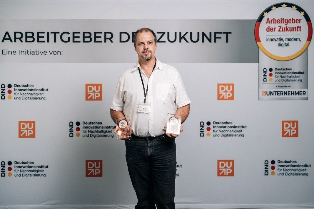 Ein Mann mit Auszeichnungen in der Hand